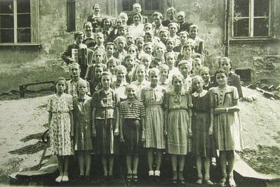 Uczniowie z rocznika 1939 przed wejsciem do szkoły (obecnie wejście tylne). Zdjęcie zrobione w latach 50.XXw. 
